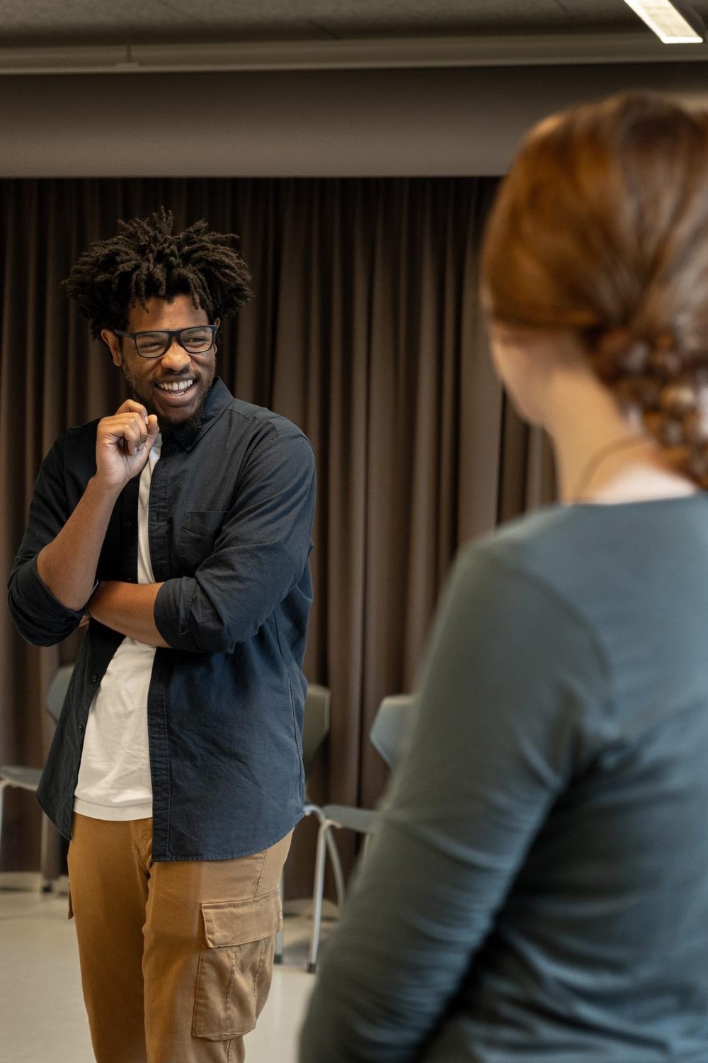 Terrance laughing while leading a workshop, a participant in the foreground