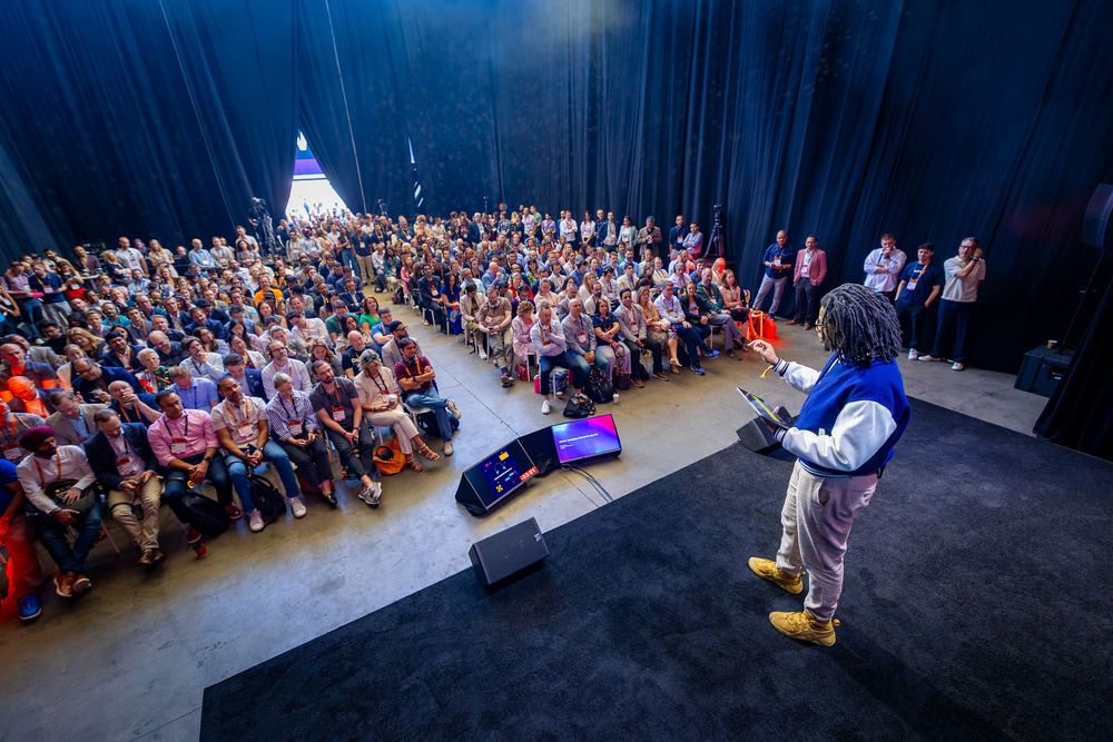 Terrance on stage at DPW New York, seen from behind, facing a packed audience