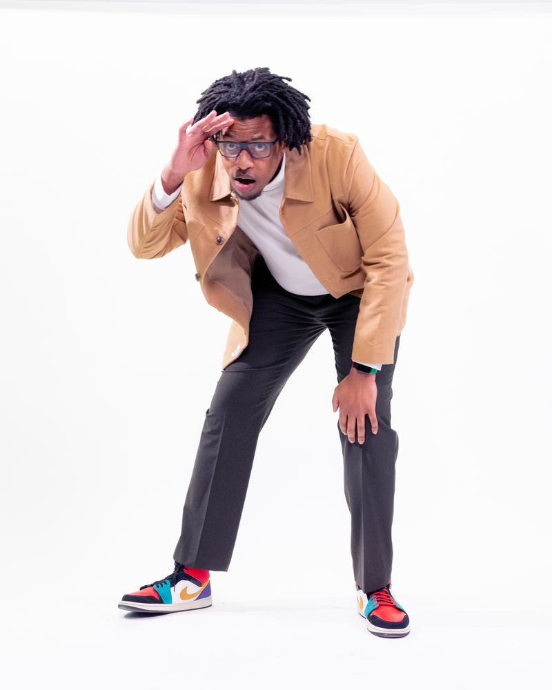 Terrance leaning forward and shading his eyes as if scanning the horizon, on a white backdrop