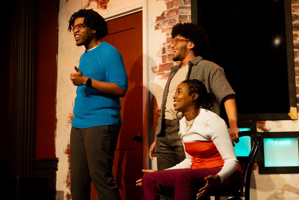 Terrance standing in a blue sweater in a scene with two castmates at The Second City