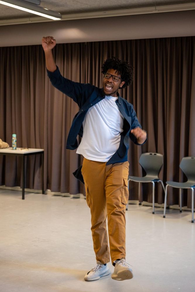 Terrance mid-move with one arm raised while leading a workshop