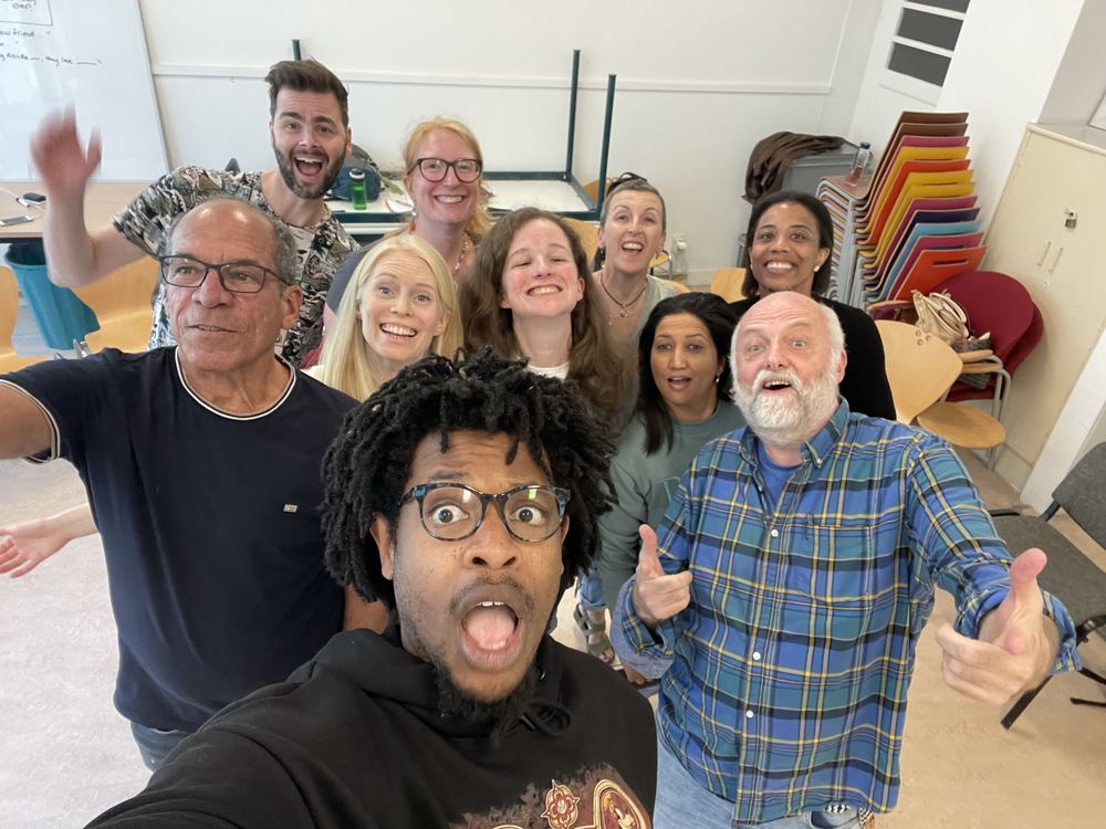 Terrance taking a wide-eyed selfie with a laughing workshop group