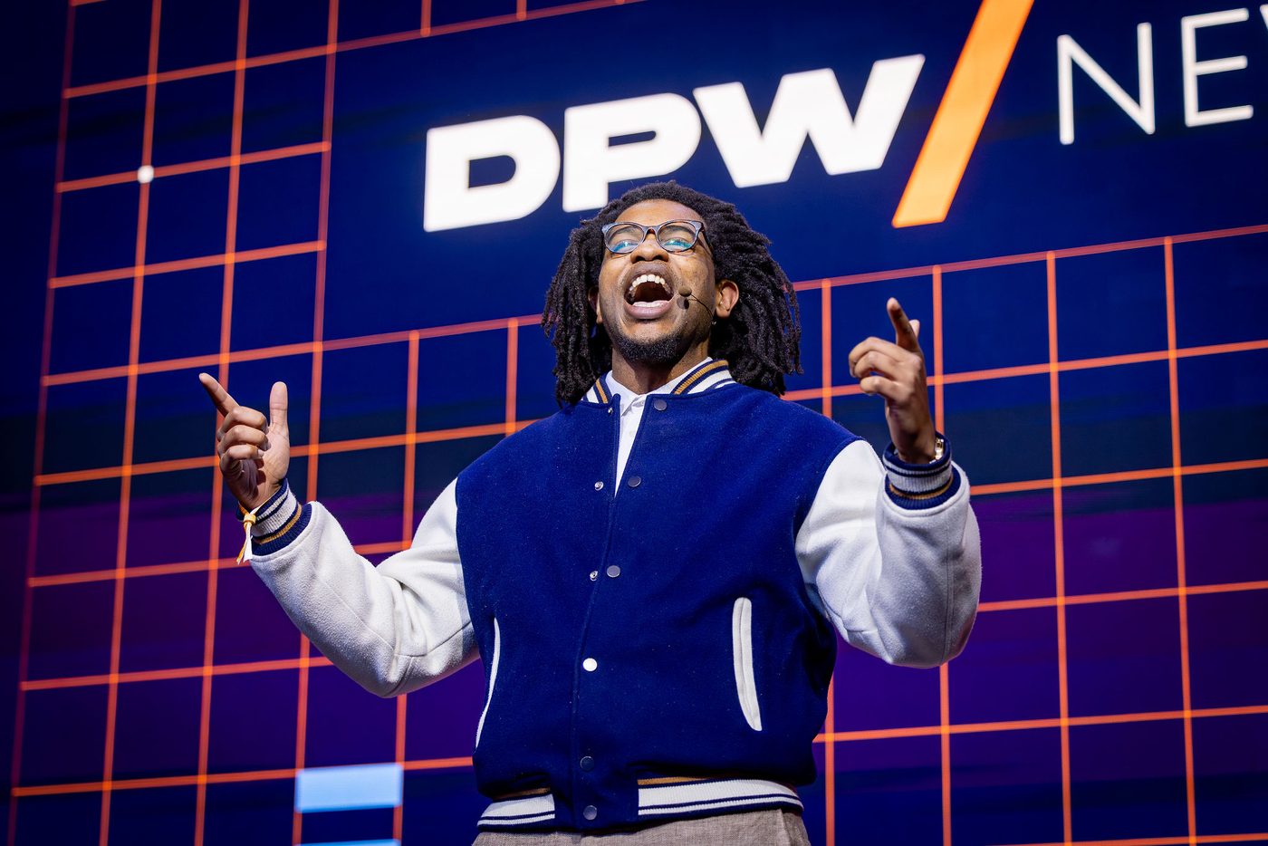 Terrance on the DPW New York main stage in a varsity jacket, arms raised mid-sentence